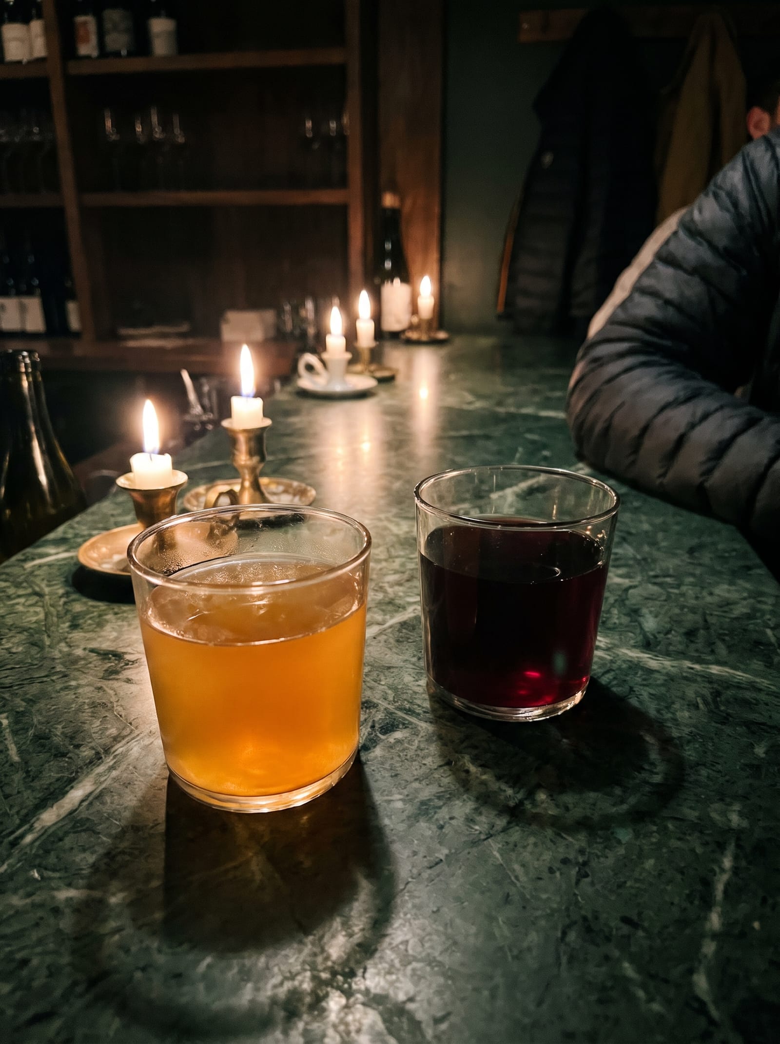 Two glasses of wine on a dark bar